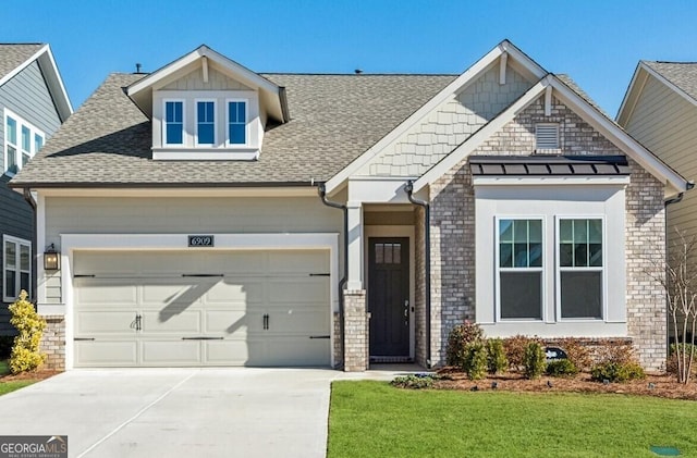 craftsman house with a garage and a front lawn