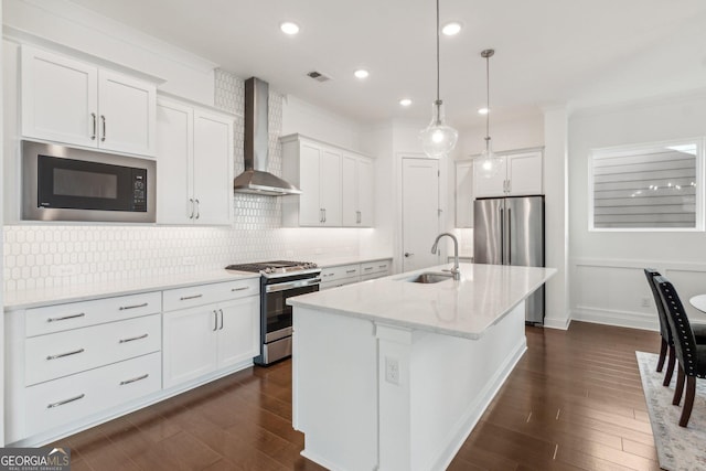 kitchen with sink, white cabinets, wall chimney exhaust hood, and appliances with stainless steel finishes