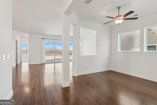 empty room featuring dark hardwood / wood-style flooring, ornamental molding, and ceiling fan