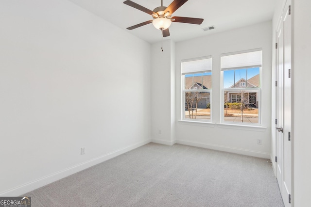 carpeted spare room with ceiling fan