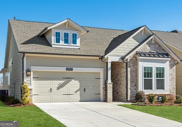 craftsman inspired home featuring cooling unit, a garage, and a front lawn