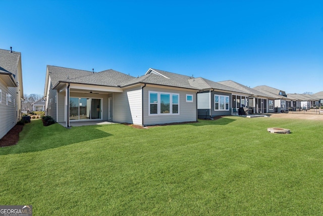 rear view of property featuring a patio and a lawn