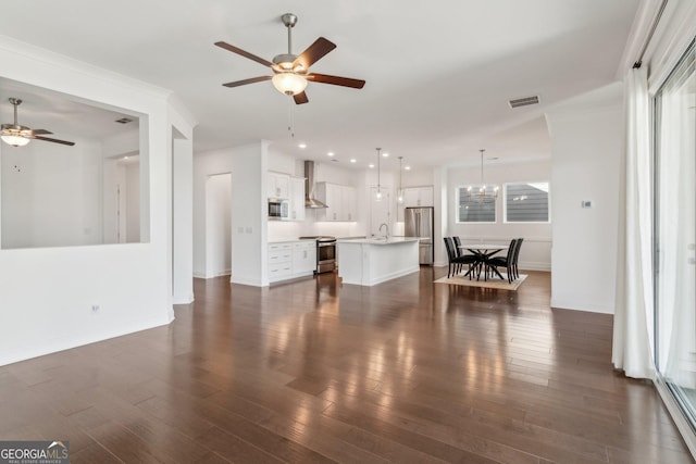 living room with ceiling fan with notable chandelier, ornamental molding, and dark hardwood / wood-style floors