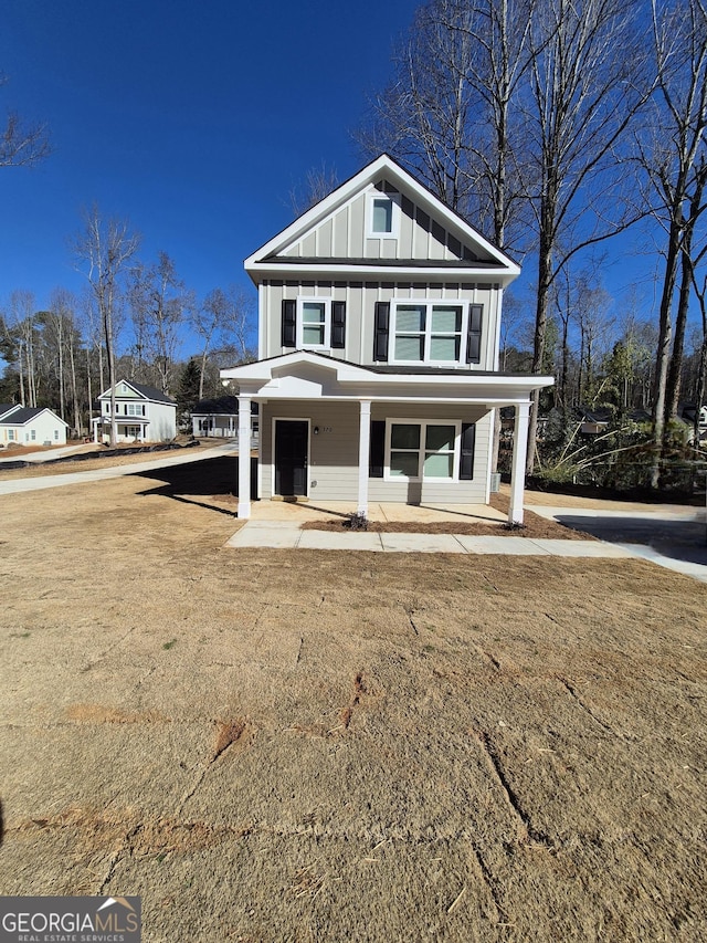 view of front of house featuring covered porch and a front lawn