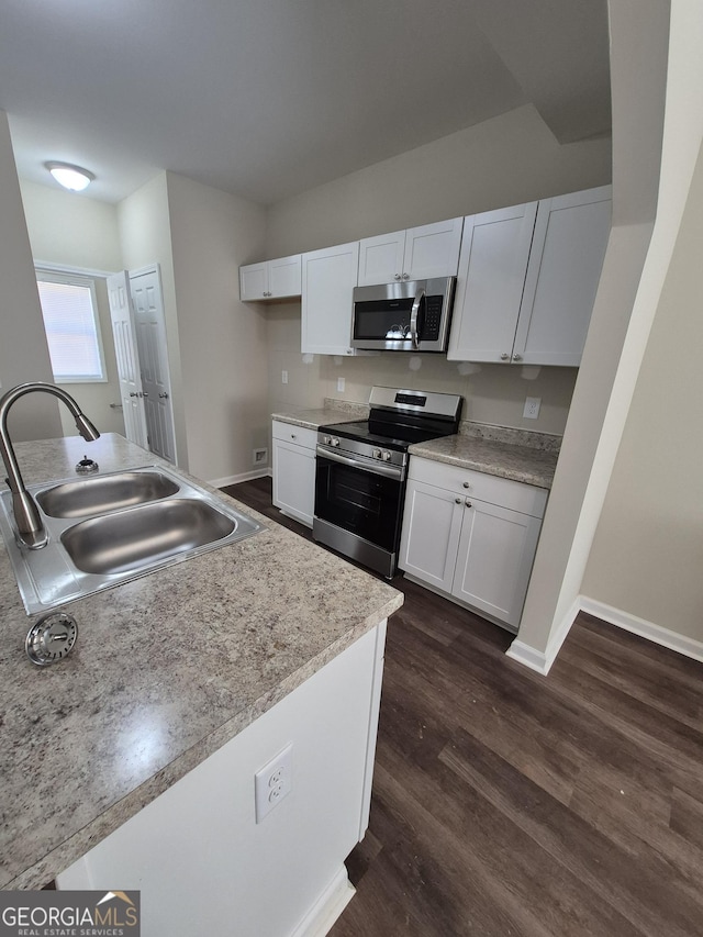 kitchen featuring white cabinetry, sink, appliances with stainless steel finishes, and dark wood-type flooring