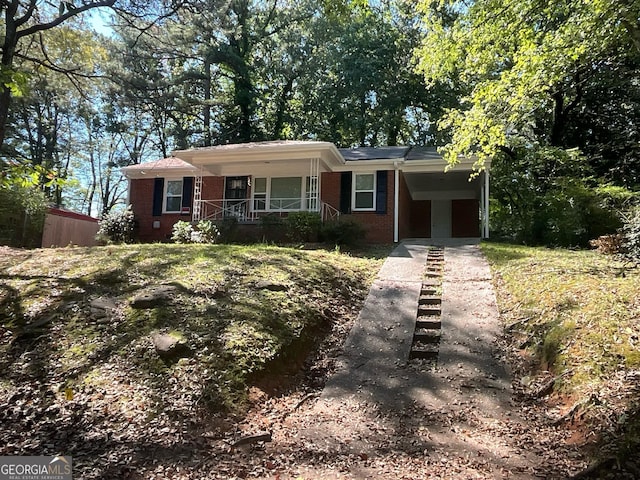 ranch-style home with covered porch and a carport