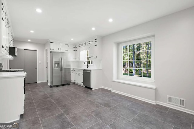 kitchen with appliances with stainless steel finishes, white cabinetry, and sink