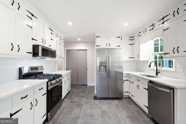 kitchen featuring white cabinetry, sink, appliances with stainless steel finishes, and tasteful backsplash