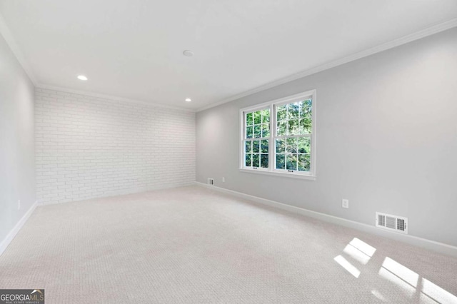 empty room with crown molding, light colored carpet, and brick wall