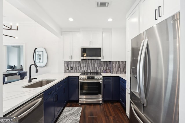 kitchen featuring light stone countertops, appliances with stainless steel finishes, sink, blue cabinetry, and white cabinetry