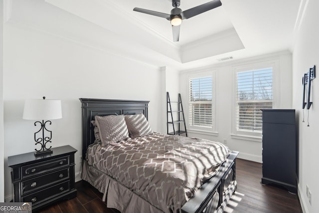 bedroom featuring ceiling fan, dark hardwood / wood-style floors, a raised ceiling, and crown molding