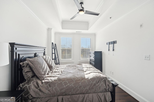 bedroom featuring dark hardwood / wood-style flooring, a raised ceiling, and ceiling fan