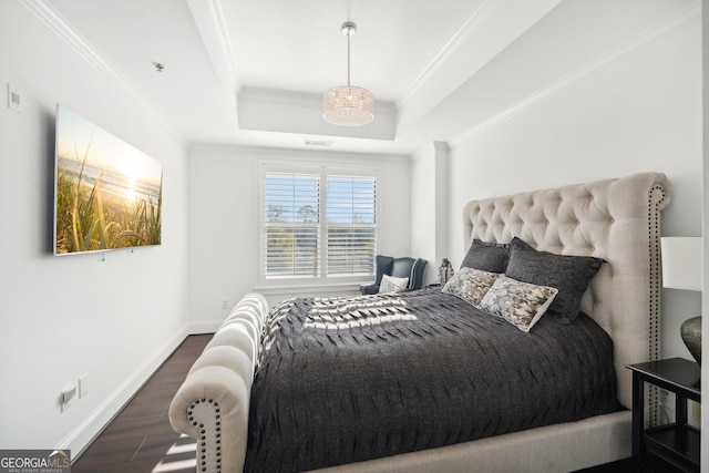 bedroom with a tray ceiling, crown molding, and dark wood-type flooring