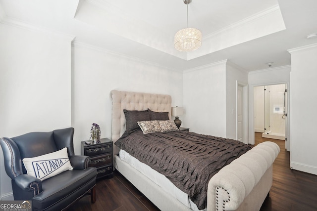 bedroom with a tray ceiling, crown molding, dark wood-type flooring, and an inviting chandelier