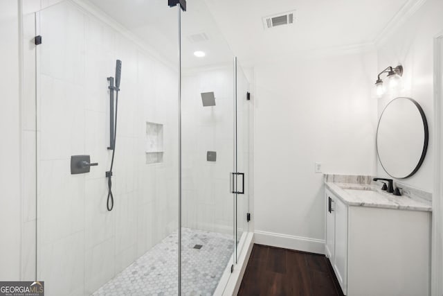 bathroom featuring hardwood / wood-style floors, vanity, an enclosed shower, and ornamental molding