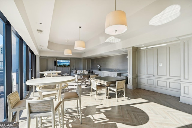 dining room featuring parquet flooring and a raised ceiling