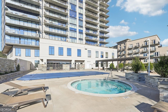 view of swimming pool featuring an in ground hot tub