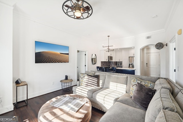 living room featuring dark hardwood / wood-style floors, ceiling fan, and crown molding