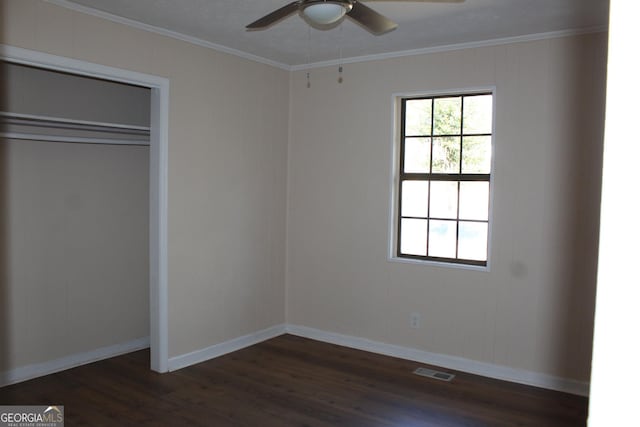 unfurnished bedroom featuring a closet, ceiling fan, crown molding, and dark hardwood / wood-style floors