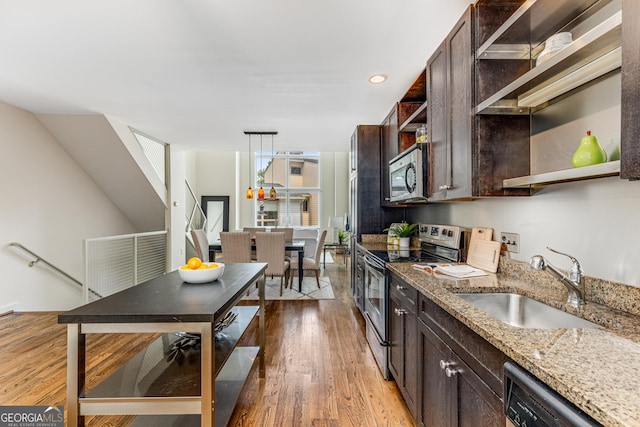 kitchen with sink, light hardwood / wood-style flooring, dark brown cabinets, light stone counters, and stainless steel appliances