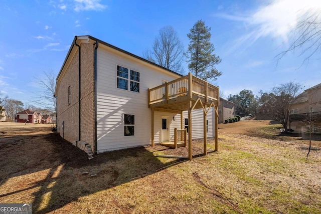 back of house with a deck and a yard