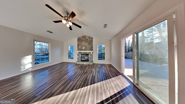 unfurnished living room featuring ceiling fan, a stone fireplace, dark hardwood / wood-style flooring, and vaulted ceiling