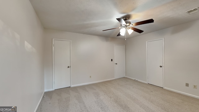 carpeted spare room featuring ceiling fan and a textured ceiling