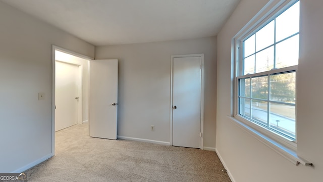 unfurnished bedroom featuring light carpet