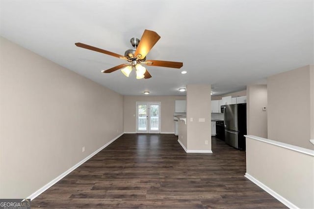 unfurnished living room with french doors, dark hardwood / wood-style floors, and ceiling fan