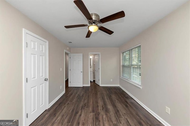 unfurnished bedroom featuring ceiling fan and dark wood-type flooring