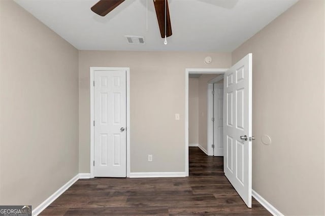 unfurnished bedroom featuring ceiling fan and dark hardwood / wood-style flooring