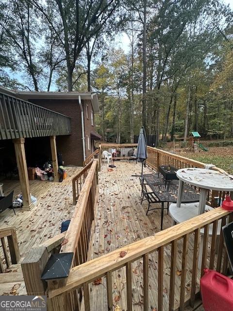 wooden deck featuring a playground