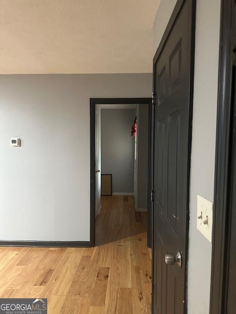 hallway with light hardwood / wood-style floors