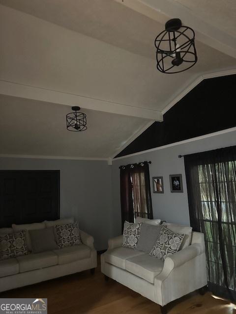 living room featuring lofted ceiling with beams, hardwood / wood-style flooring, and a notable chandelier