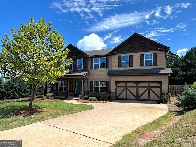 craftsman house with a garage and a front lawn