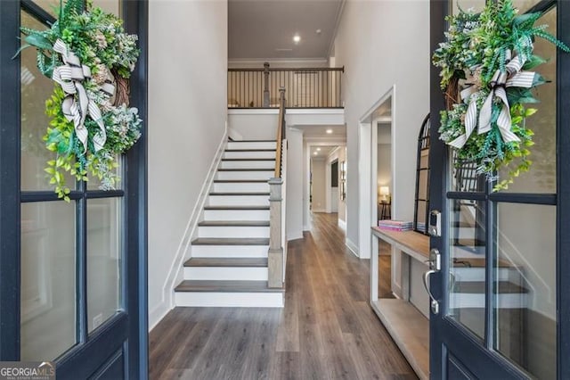 foyer entrance featuring crown molding, dark hardwood / wood-style flooring, and french doors