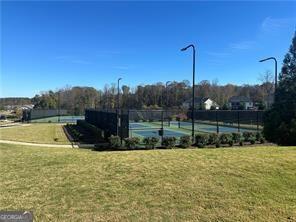 view of tennis court featuring basketball hoop