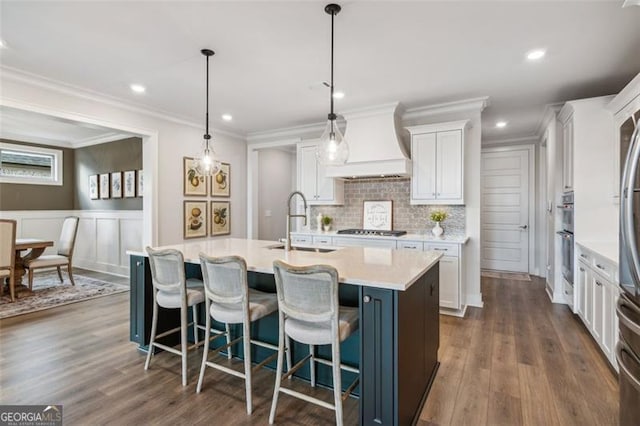 kitchen featuring decorative light fixtures, premium range hood, white cabinetry, decorative backsplash, and stainless steel appliances