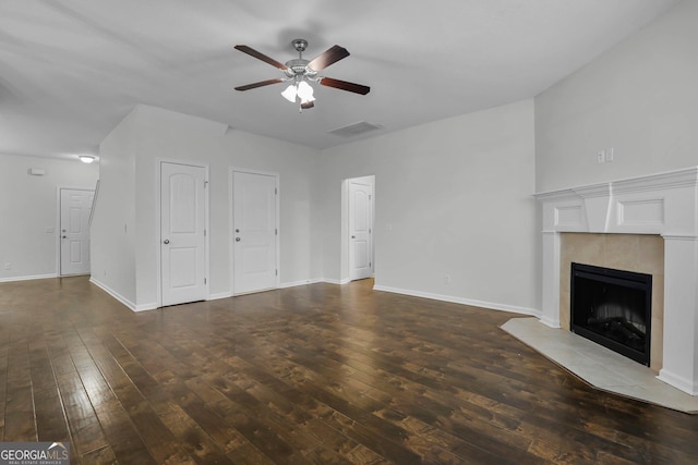 unfurnished living room featuring a fireplace, dark hardwood / wood-style flooring, and ceiling fan