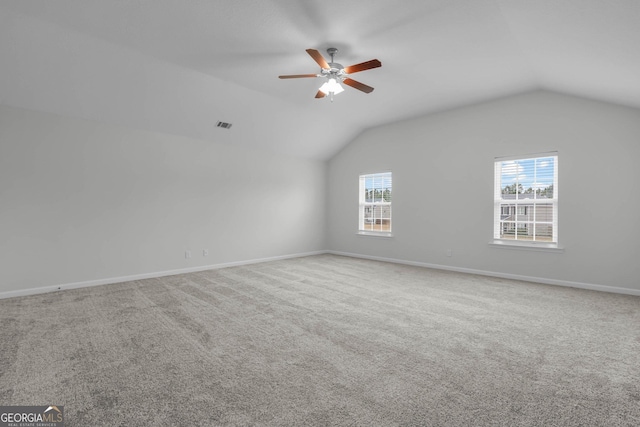 empty room featuring ceiling fan, carpet floors, and vaulted ceiling