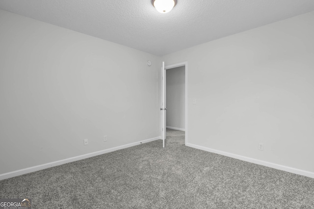 unfurnished room featuring carpet floors and a textured ceiling