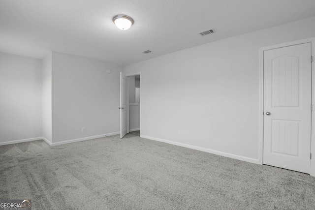 spare room with carpet flooring and a textured ceiling