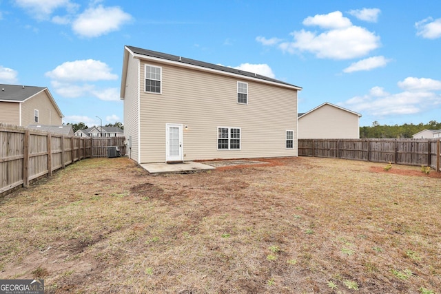 back of house featuring a patio area, a yard, and central AC