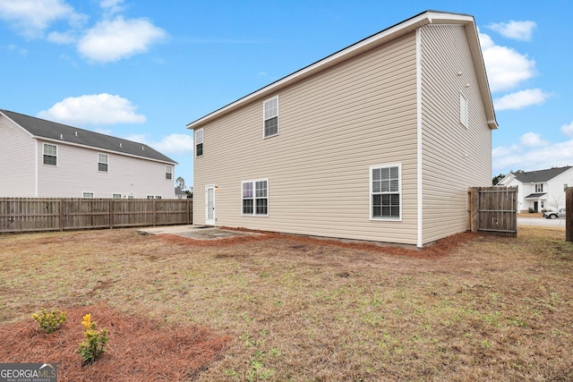 rear view of house with a patio area and a yard