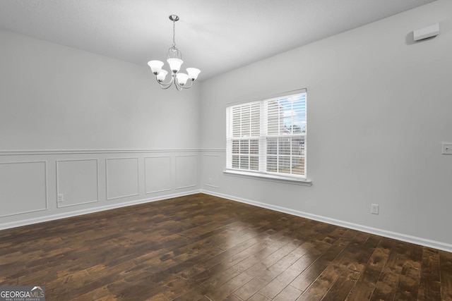 unfurnished room with dark hardwood / wood-style floors and a chandelier