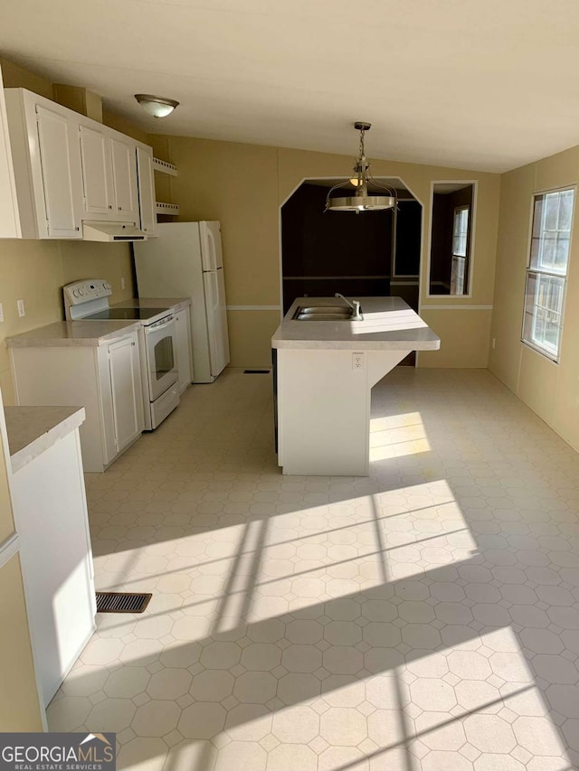 kitchen featuring a kitchen bar, white appliances, sink, pendant lighting, and white cabinets