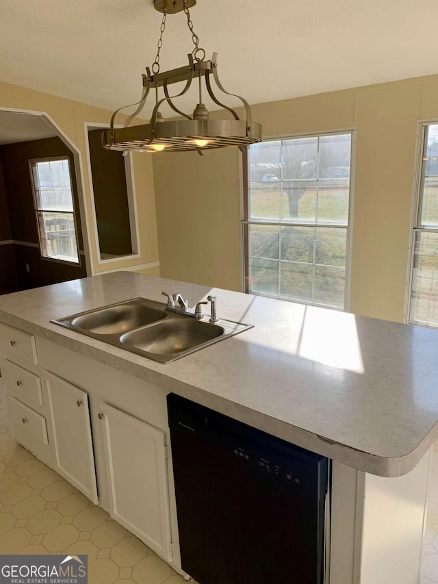 kitchen featuring dishwasher, sink, a chandelier, pendant lighting, and white cabinets