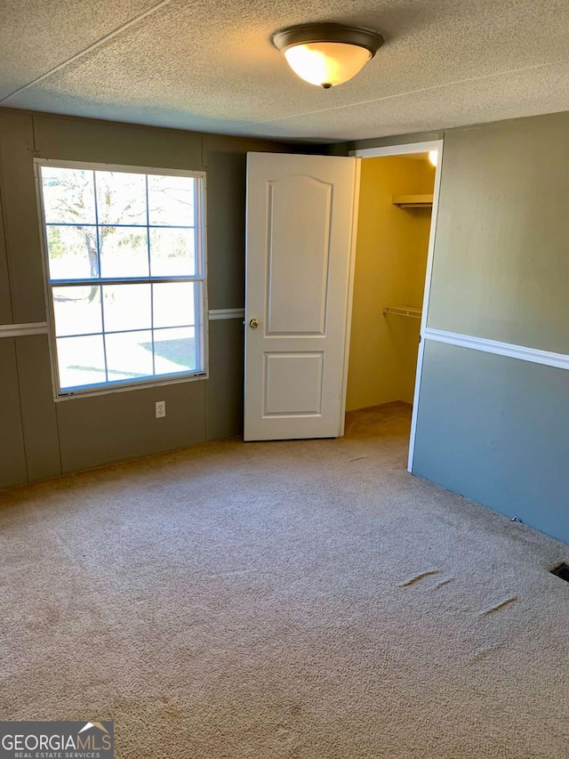 carpeted spare room with a textured ceiling