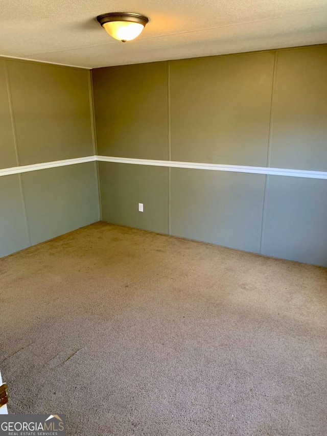 carpeted empty room with a textured ceiling