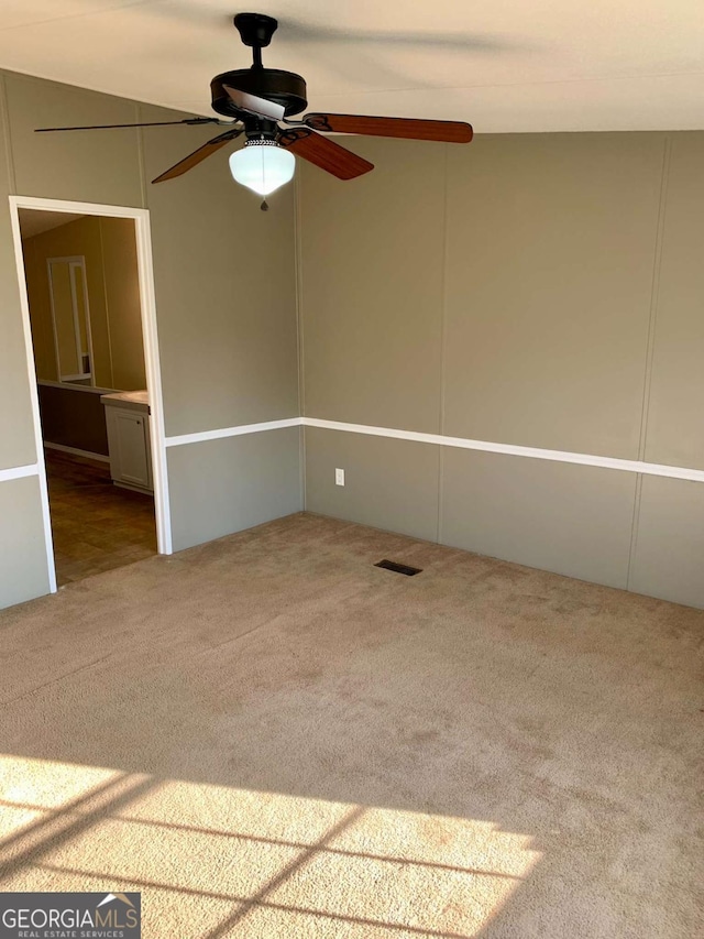 carpeted empty room featuring ceiling fan